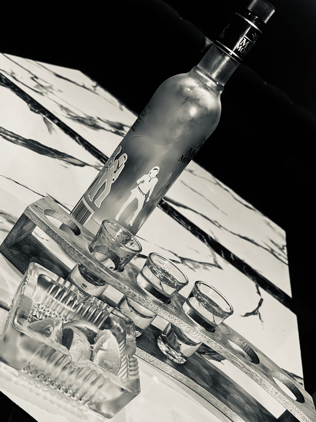 Spirit bottle with a wooden rack of filled shot glasses